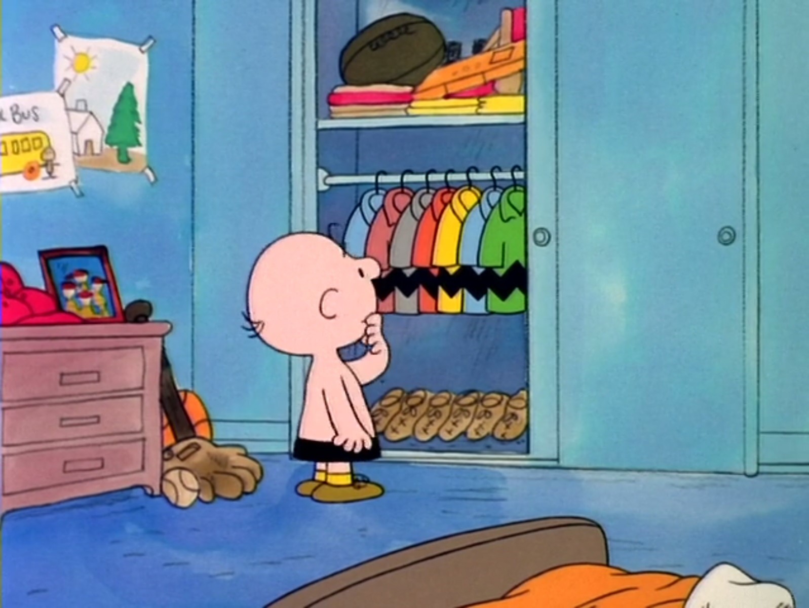 Charlie Brown stands in front of his closet, filled with nearly identical shirts with his patented zigzag black line running across each one, the only difference being the color.